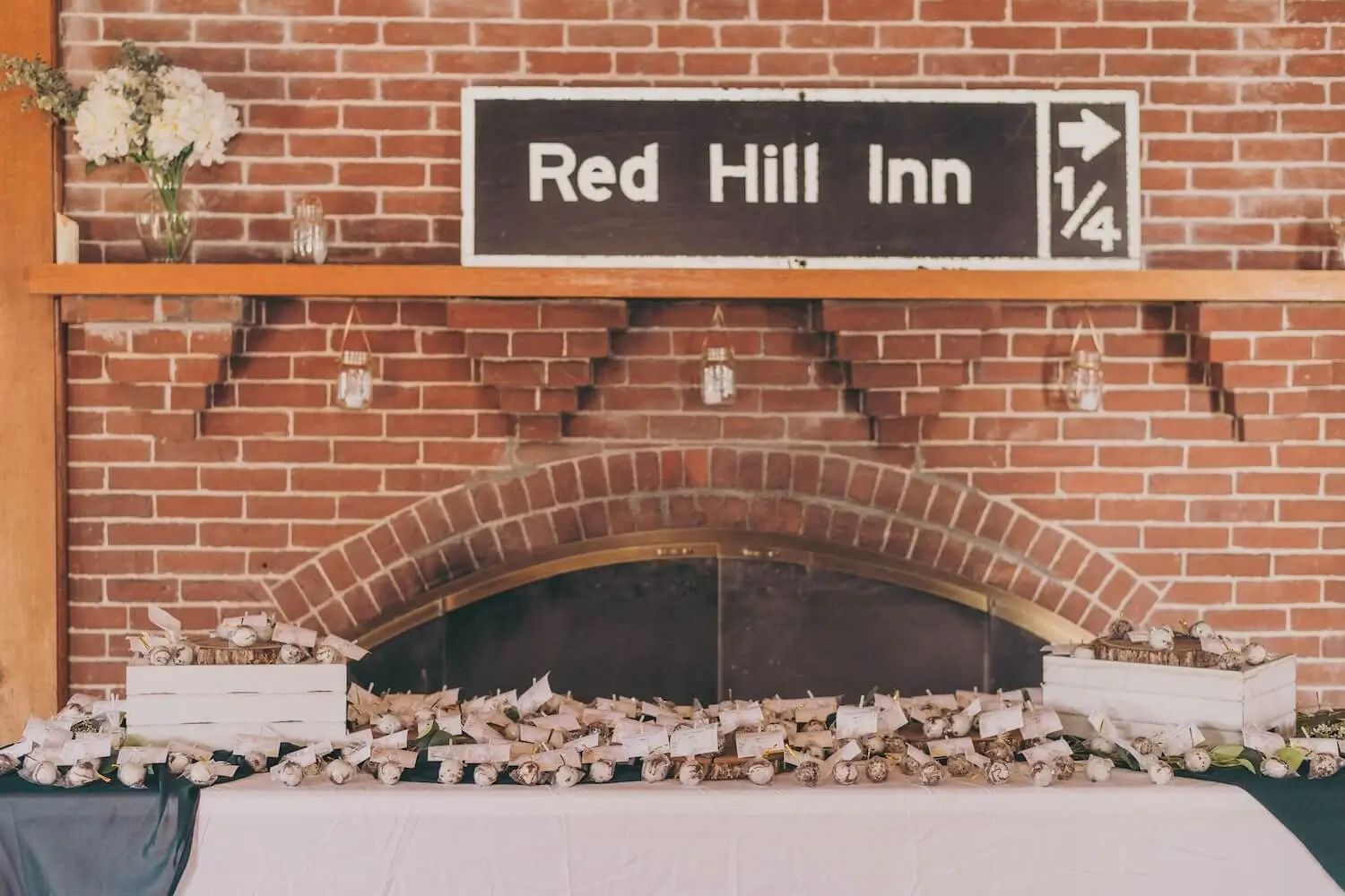 A brick fireplace with the Red Hill Inn sign above it